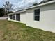 Exterior of single-story home featuring white stucco and screened in porch at 13532 14Th St, Dade City, FL 33525