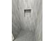 Modern shower with decorative tile, a built-in shelf, and grey, hexagon floor at 13532 14Th St, Dade City, FL 33525