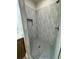 Stylish shower with decorative tile, a built-in shelf, and grey, hexagon floor at 13532 14Th St, Dade City, FL 33525