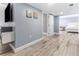 Open finished basement featuring wood floors, TV, seating, and an open bedroom at 1390 Gulf Blvd # Ph-5, Clearwater, FL 33767
