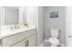 Stylish half bathroom featuring a white vanity, toilet and beach decor at 1390 Gulf Blvd # Ph-5, Clearwater, FL 33767