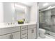 Well-lit bathroom featuring double vanity, a glass enclosed shower, and marble-look flooring at 1390 Gulf Blvd # Ph-5, Clearwater, FL 33767