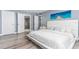 Bedroom with ensuite bathroom, wood-look floors, and beach themed art at 1390 Gulf Blvd # Ph-5, Clearwater, FL 33767