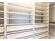 This walk-in closet has custom white built-in shelving and drawers for maximum storage and organization at 1390 Gulf Blvd # Ph-5, Clearwater, FL 33767