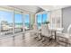 Bright dining room with water view, floor to ceiling windows, hardwood floors, and stylish white table at 1390 Gulf Blvd # Ph-5, Clearwater, FL 33767