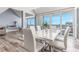 Open concept dining room with water view, hardwood floors, and stylish white table at 1390 Gulf Blvd # Ph-5, Clearwater, FL 33767