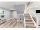 Cozy entryway featuring wood floors, stairs with glass railing, and beach themed wall decor at 1390 Gulf Blvd # Ph-5, Clearwater, FL 33767