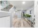 Bright entryway with wood floors, glass railed staircase, and sliding mirrored closet at 1390 Gulf Blvd # Ph-5, Clearwater, FL 33767