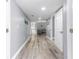 Hallway with gray walls and wood floors leading to living area at 1390 Gulf Blvd # Ph-5, Clearwater, FL 33767