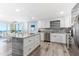 Modern kitchen with stainless steel appliances, white cabinets, granite countertops and dining area view at 1390 Gulf Blvd # Ph-5, Clearwater, FL 33767
