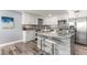 Modern kitchen with stainless steel appliances, white cabinets, granite countertops and breakfast bar at 1390 Gulf Blvd # Ph-5, Clearwater, FL 33767