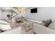 Comfortable living room featuring modern sofas, gray walls, and staircase access at 1390 Gulf Blvd # Ph-5, Clearwater, FL 33767