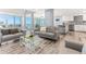 Open-concept living room with modern gray sofas, and water views through large windows at 1390 Gulf Blvd # Ph-5, Clearwater, FL 33767