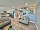 Open living room with a kitchen view and a staircase with a glass railing to the second level at 1390 Gulf Blvd # Ph-5, Clearwater, FL 33767