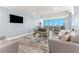 Bright living room featuring neutral furnishings and views of the water from sliding doors at 1390 Gulf Blvd # Ph-5, Clearwater, FL 33767