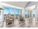 Open floor plan with two chairs and sliding glass doors accessing balcony with water view at 1390 Gulf Blvd # Ph-5, Clearwater, FL 33767