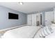 Comfortable main bedroom with ensuite bathroom, large tv, and light-colored floors at 1390 Gulf Blvd # Ph-5, Clearwater, FL 33767