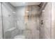 Close-up of glass-enclosed walk-in shower featuring tile walls and rainfall shower head at 1390 Gulf Blvd # Ph-5, Clearwater, FL 33767