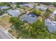 Aerial view showcasing home with screened pool, storage shed, privacy fence, and lush landscaping at 1450 Palmetto St, Clearwater, FL 33755
