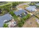 An aerial shot shows a home's backyard with a screened pool, lush palms, and a fenced perimeter at 1450 Palmetto St, Clearwater, FL 33755