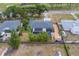 An aerial view of a home with screened-in pool, mature trees and landscaping in a residential neighborhood at 1450 Palmetto St, Clearwater, FL 33755