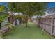 Backyard putting green surrounded by lush tropical landscaping and a privacy fence at 1450 Palmetto St, Clearwater, FL 33755