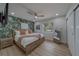 Bedroom features a stylish tropical wallpaper accent wall, light wood floors, and a large window at 1450 Palmetto St, Clearwater, FL 33755