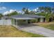 Charming home showcasing a covered carport and well-maintained landscaping at 1450 Palmetto St, Clearwater, FL 33755