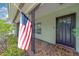 Close-up view of the front porch with an American flag and decorative ironwork at 1450 Palmetto St, Clearwater, FL 33755