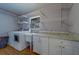Bright laundry room featuring modern washer and dryer, utility sink, updated cabinets, and ample shelving at 1450 Palmetto St, Clearwater, FL 33755