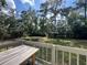 View of the backyard from the deck, showcasing the lawn, mature trees, and a trampoline at 1510 Sabra Dr, Brooksville, FL 34601