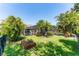 Landscaped backyard with lush tropical foliage, a screened pool enclosure, and a covered outdoor grilling area at 15422 Starling Crossing Dr, Lithia, FL 33547
