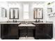 Elegant bathroom featuring double sinks with granite counters, decorative mirrors, and ample storage at 15422 Starling Crossing Dr, Lithia, FL 33547