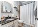 Bathroom featuring black granite countertops and decorative shelving with tub/shower at 15422 Starling Crossing Dr, Lithia, FL 33547