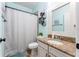 Light blue bathroom with a single sink vanity and a shower/tub with patterned curtain at 15422 Starling Crossing Dr, Lithia, FL 33547