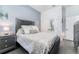 Bedroom with a queen-sized bed, stylish gray furnishings and wood flooring at 15422 Starling Crossing Dr, Lithia, FL 33547