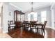 Formal dining room with dark wood floors, elegant chandelier, and decorative china cabinet at 15422 Starling Crossing Dr, Lithia, FL 33547