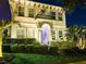 Striking night view showcasing the home's elegant architecture and professional landscaping, highlighting a warm and inviting ambiance at 15422 Starling Crossing Dr, Lithia, FL 33547