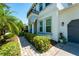Elegant home with a well-kept lawn, neat bushes, a charming arched entryway, and a gray garage door at 15422 Starling Crossing Dr, Lithia, FL 33547