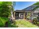 Outdoor gazebo featuring covered grills, tropical landscaping, and adjacent screened pool at 15422 Starling Crossing Dr, Lithia, FL 33547
