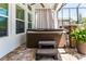 Outdoor hot tub with privacy curtain, exterior brick pavers, and lush potted plant at 15422 Starling Crossing Dr, Lithia, FL 33547
