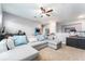 Spacious living room with a sectional couch, ceiling fan, and gaming and aquarium features at 15422 Starling Crossing Dr, Lithia, FL 33547