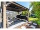 Outdoor gazebo with a peaked roof covering a seating area and two grilling stations overlooking the pool at 15422 Starling Crossing Dr, Lithia, FL 33547