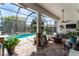 Screened-in pool with a covered patio, tropical foliage, and an outdoor kitchen at 15422 Starling Crossing Dr, Lithia, FL 33547