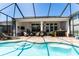 Resort style screened-in outdoor living space with pool, seating, bar and ceiling fans at 15422 Starling Crossing Dr, Lithia, FL 33547