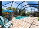 Screened pool area featuring a kidney-shaped pool, brick pavers, seating, and lush tropical landscaping at 15422 Starling Crossing Dr, Lithia, FL 33547