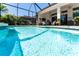 A sunny in-ground pool with screened-in lanai and outdoor seating is great for entertaining at 15422 Starling Crossing Dr, Lithia, FL 33547