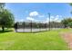 Enjoy a well-maintained tennis court with lighting and fencing for recreational play and exercise in a private setting at 15422 Starling Crossing Dr, Lithia, FL 33547