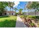 Landscaped walking path leading to the community tennis courts with blooming trees at 15422 Starling Crossing Dr, Lithia, FL 33547