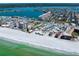 Breathtaking aerial view of a coastal community showcasing a pristine beach, buildings, and serene waterways at 17735 Gulf Blvd # 304, Redington Shores, FL 33708